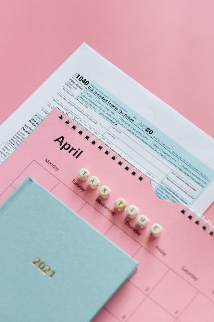 IRS Form 1040 and April planner on pastel background, symbolizing tax season.